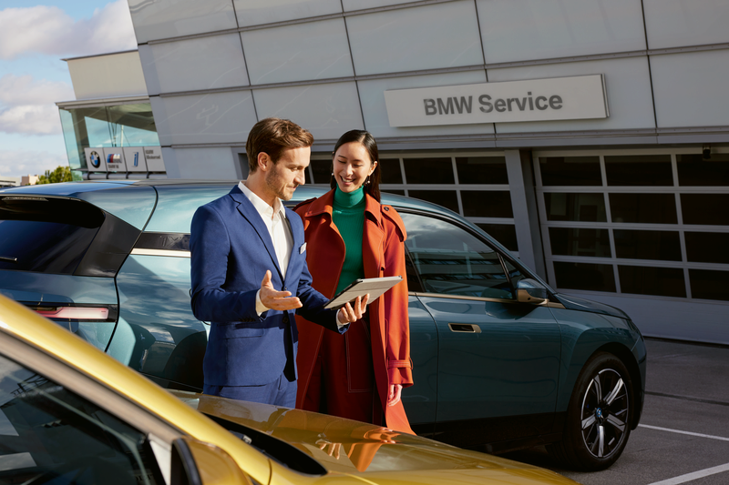 BMW Service, uitmuntende Service binnen uw fleet overeenkomst. Vrouw krijgt informatie over haar BMW iX